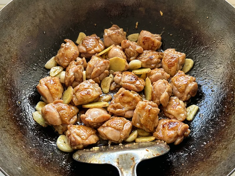 腌好的鸡肉倒入锅中翻炒